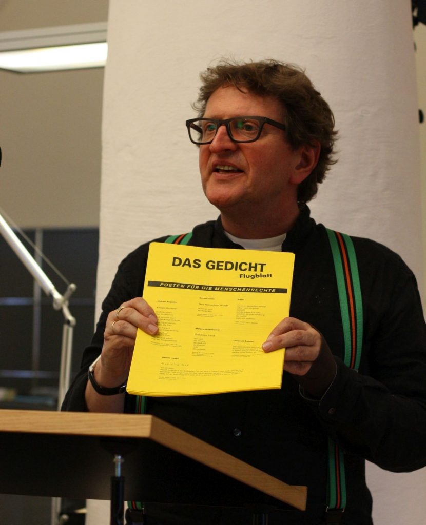Anton G. Leitner, Herausgeber von DAS GEDICHT, präsentiert ein DAS GEDICHT-Flugblatt, Reminiszenz an »Der Zettel» und zugleich Werkzeug im Einsatz für Menschenrechte. Foto: Jan-Eike Hornauer